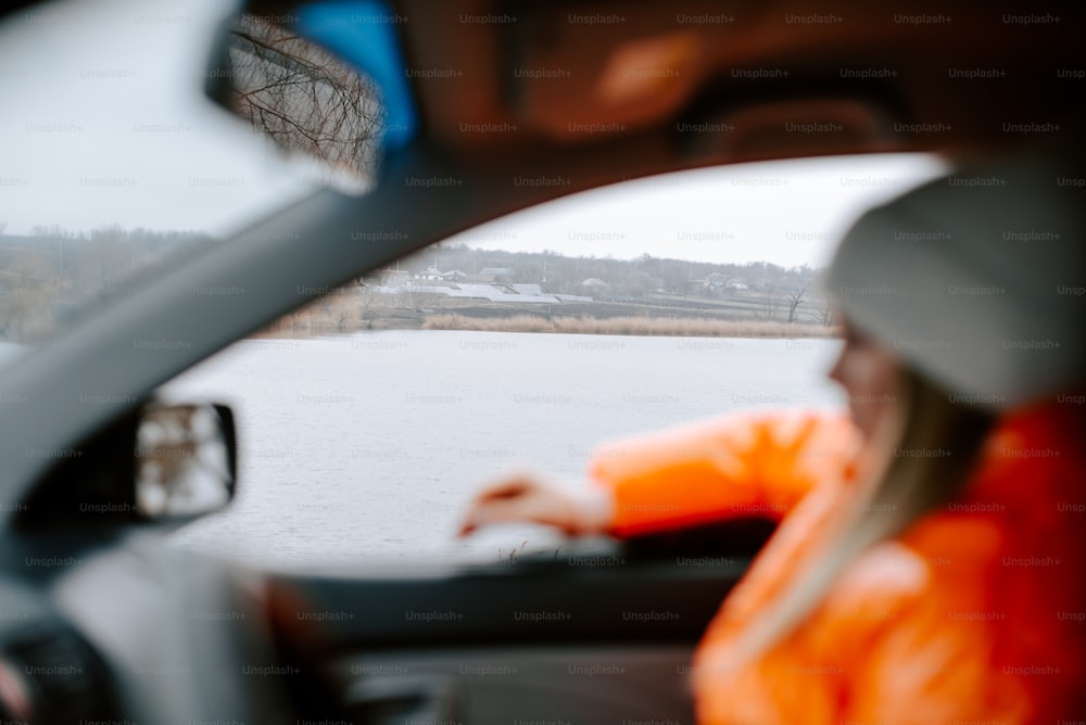 a woman sitting in a car looking out the window