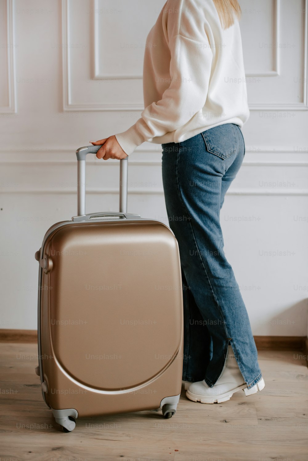 그녀의 손에 여행 가방을 들고 서있는 여자