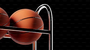 three basketballs in a rack on a black background