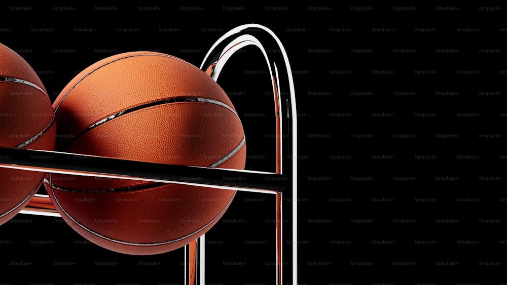 three basketballs in a rack on a black background