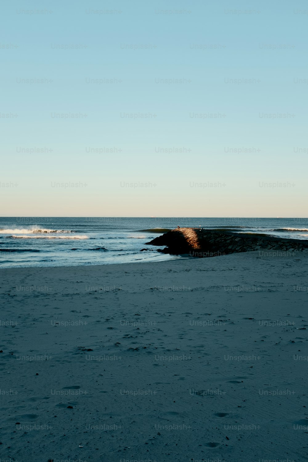 Una persona caminando en una playa cerca del océano