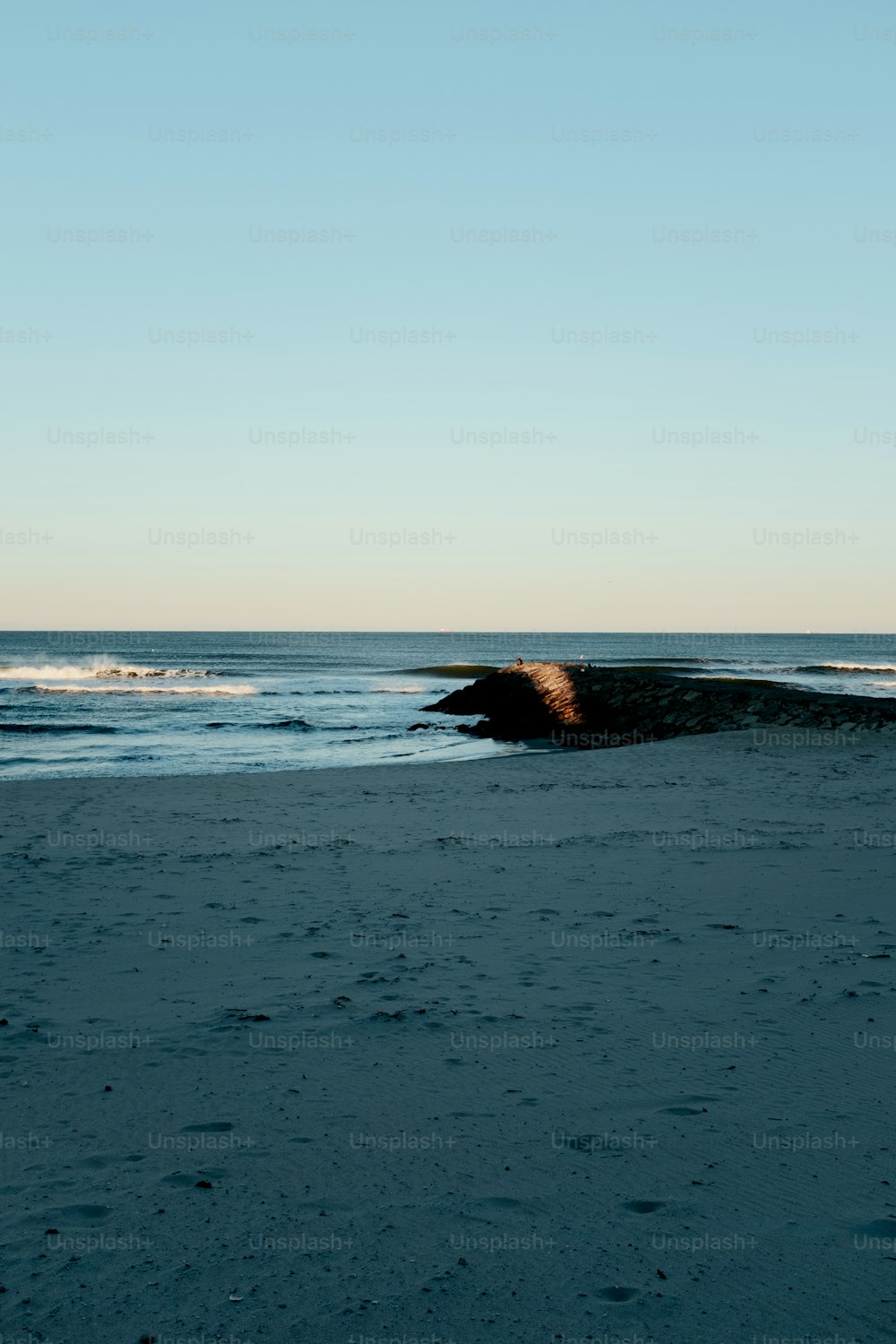Una persona che cammina su una spiaggia vicino all'oceano