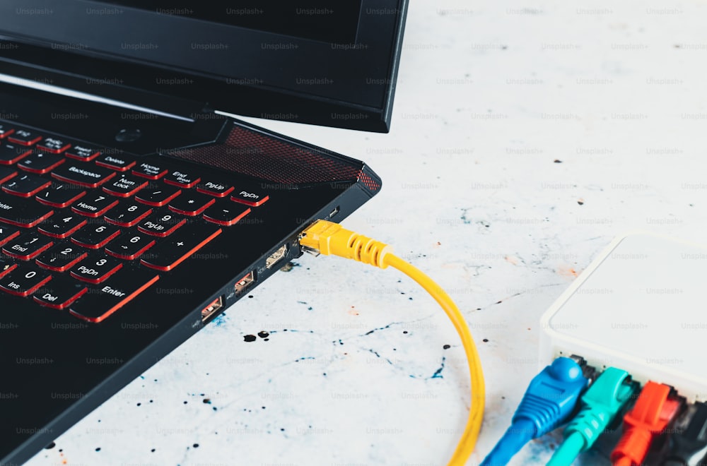 um laptop com um cabo amarelo conectado a ele