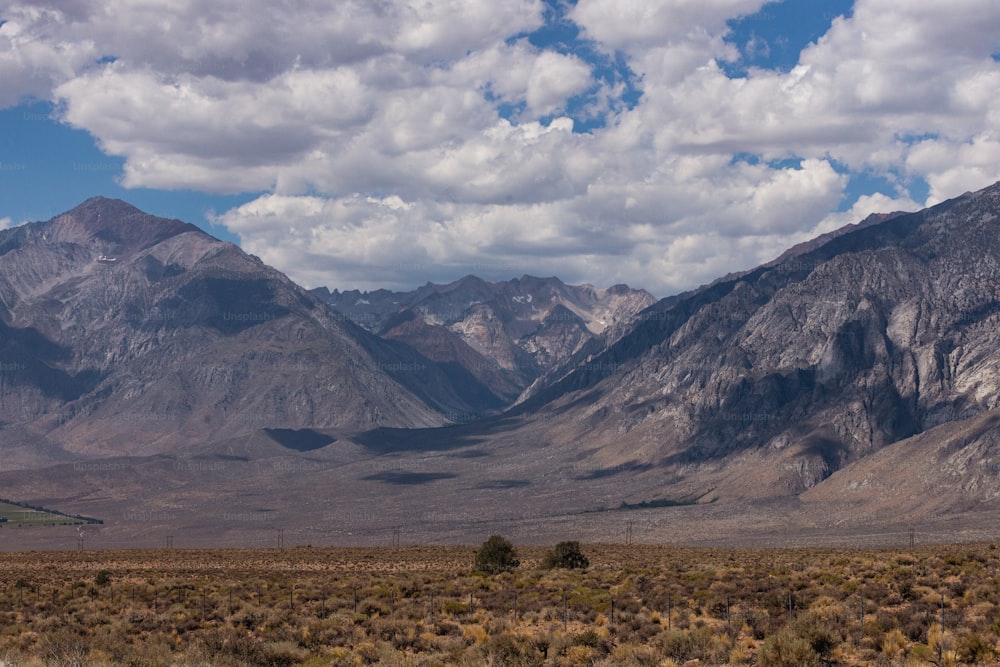 a mountain range with a few clouds in the sky