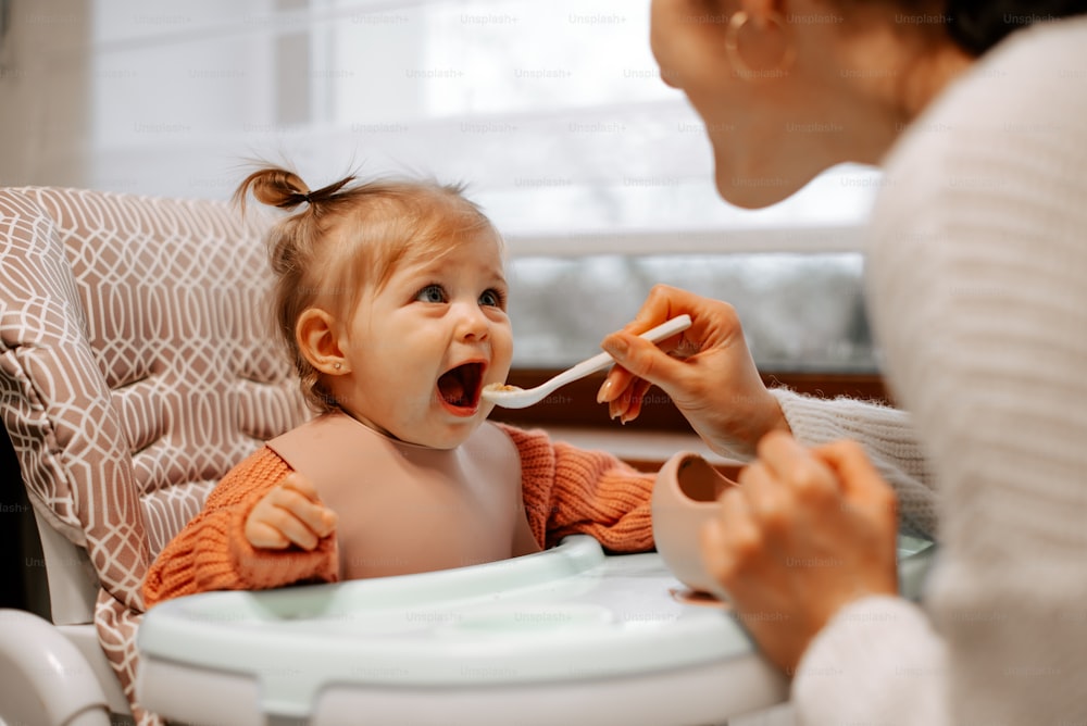 Una mujer alimentando a un bebé con una cuchara