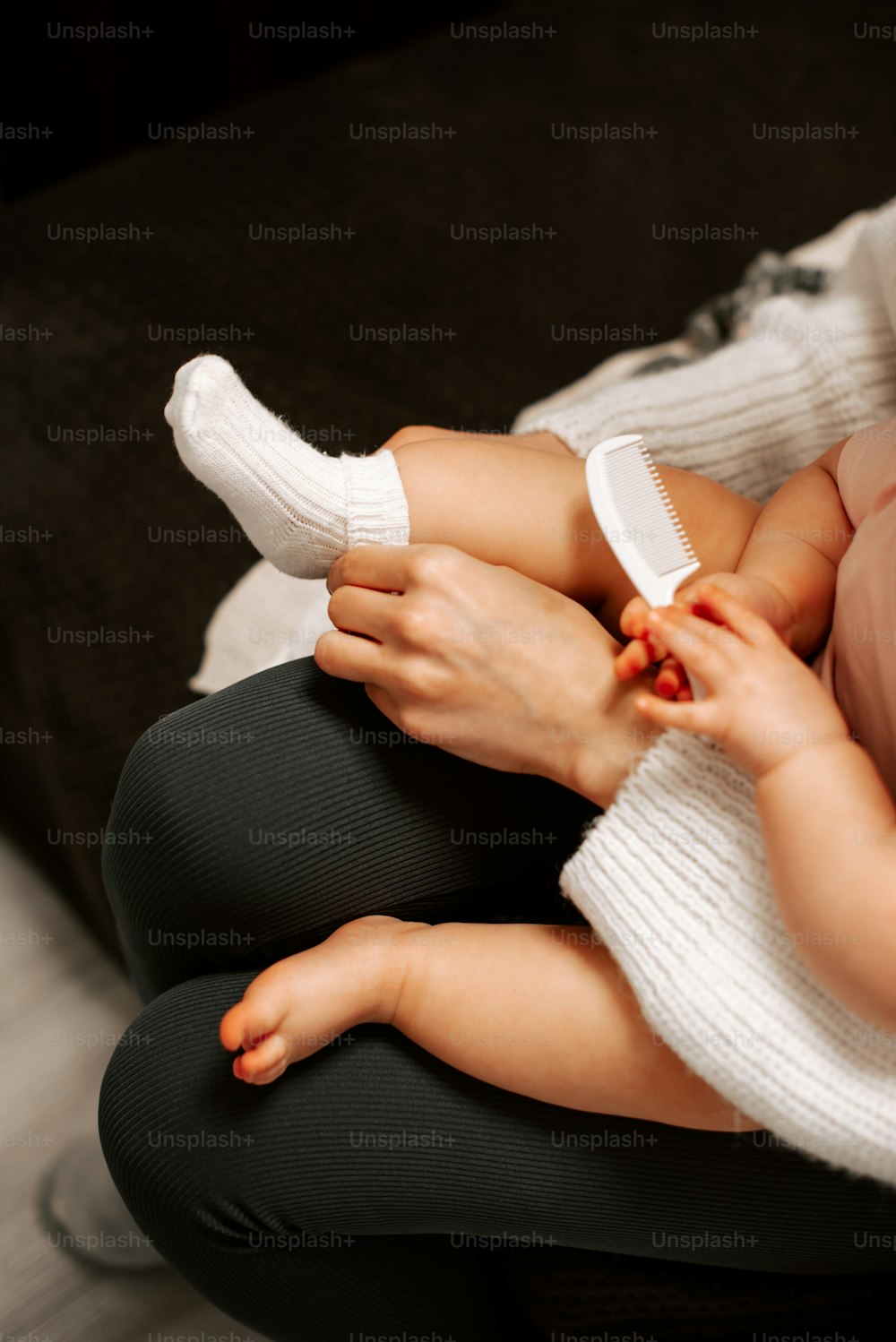 Une femme tenant un bébé avec une brosse à la main