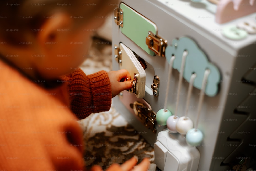 a little girl playing with a toy machine
