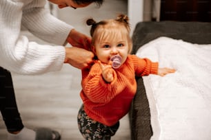 a woman is putting a pacifier to a little girl