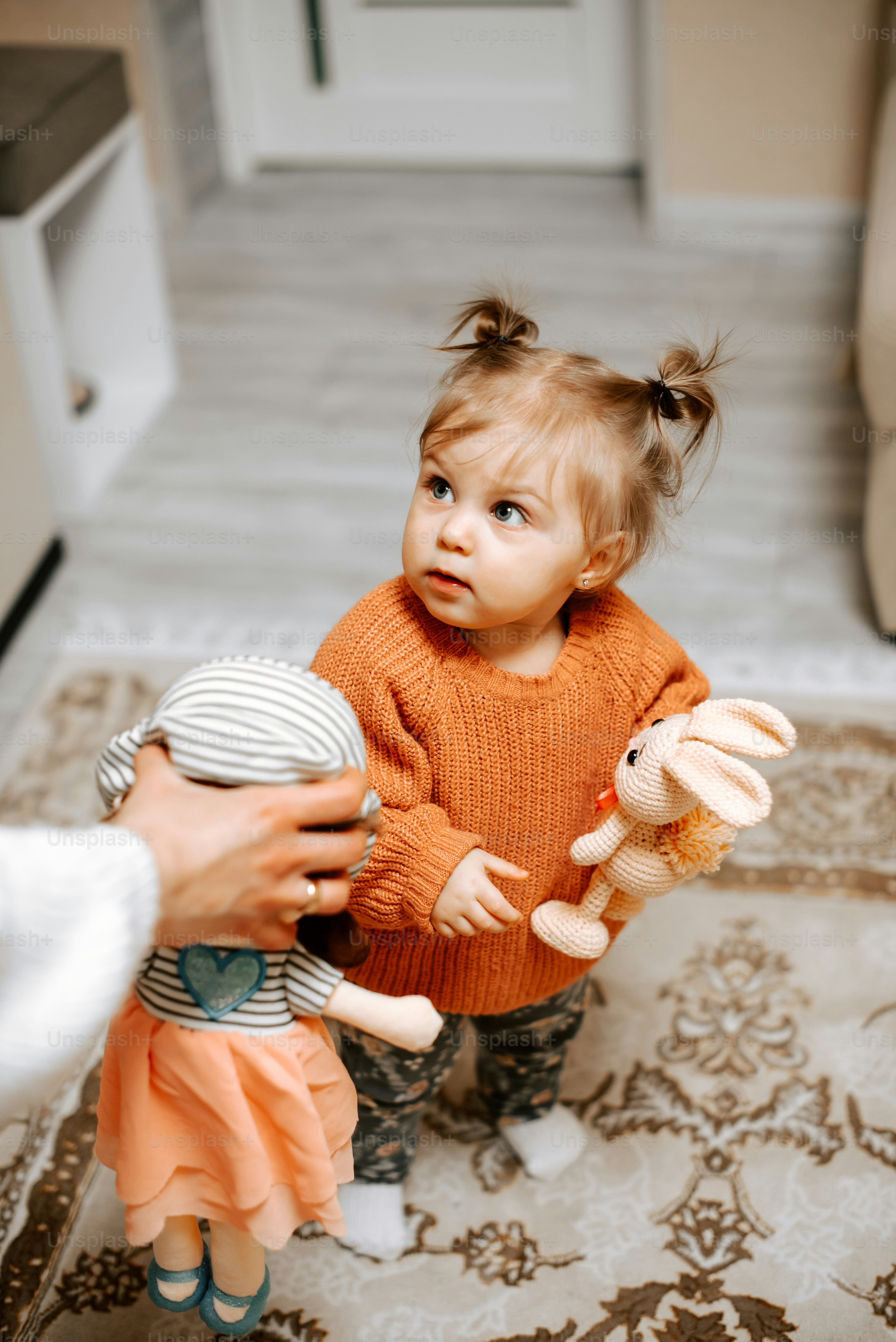 a little girl holding a stuffed animal in her hands
