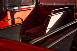 a red and black bus with two seats and a window