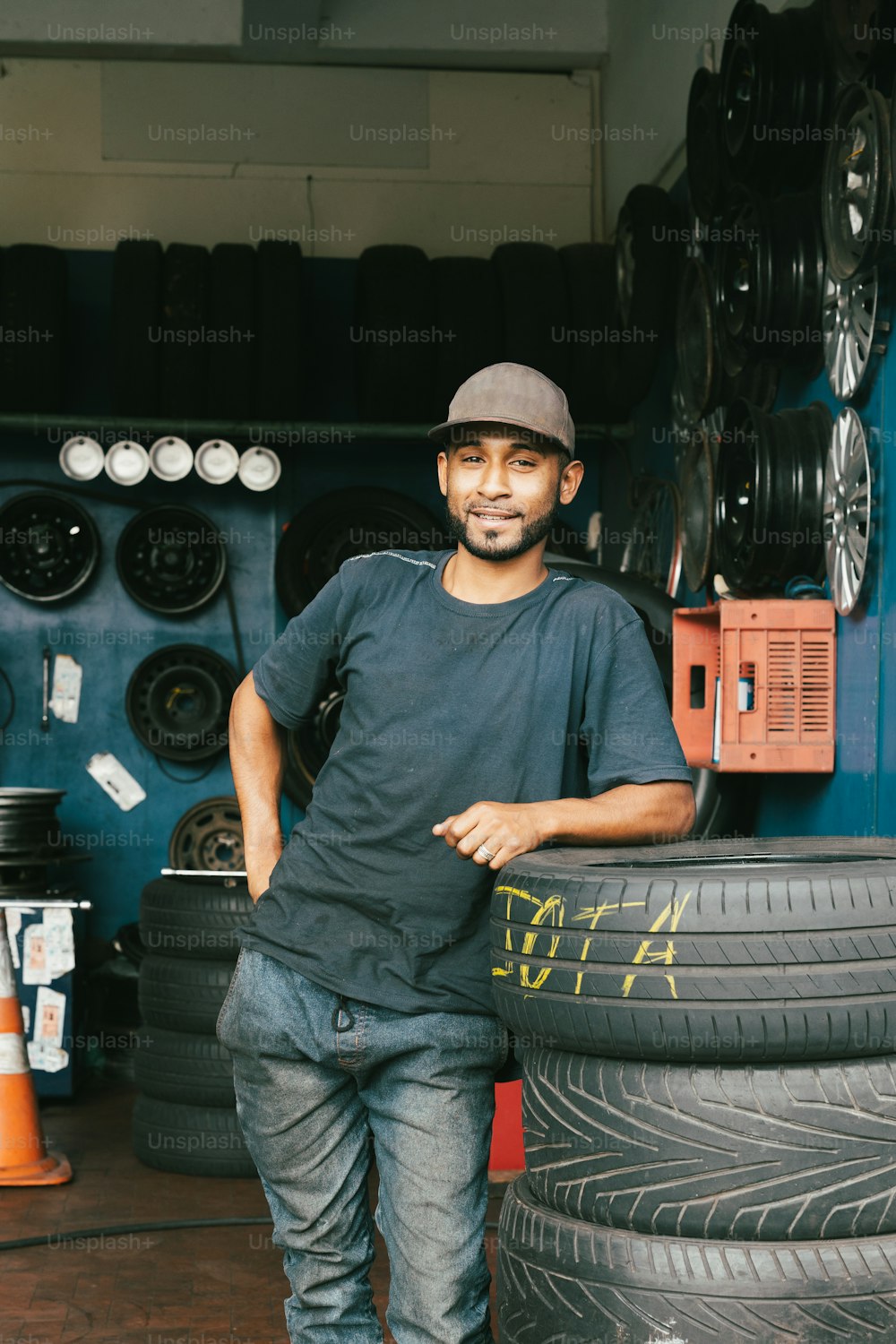 Un hombre parado junto a una pila de neumáticos