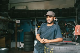 Ein Mann steht neben einem Reifenhaufen