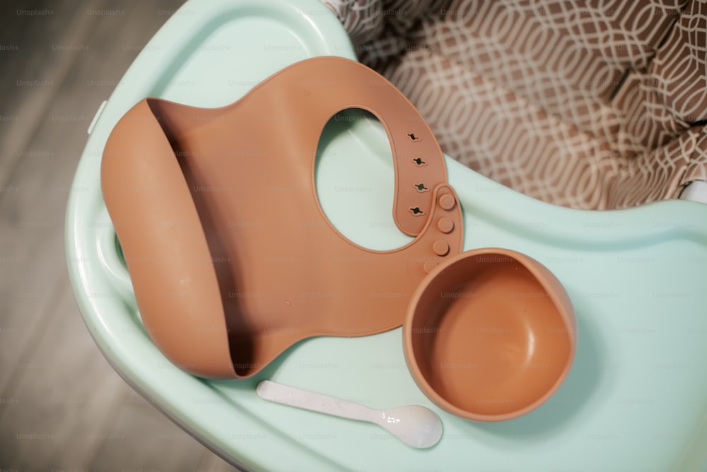 a baby seat with a bowl and spoon on it