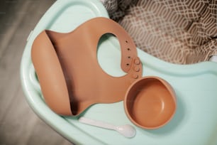 a baby seat with a bowl and spoon on it