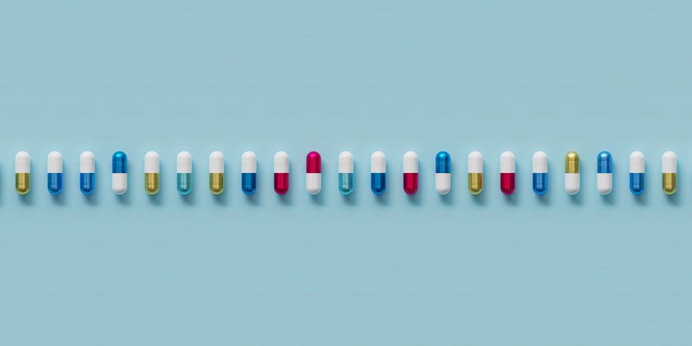 une rangée de pilules multicolores sur fond bleu