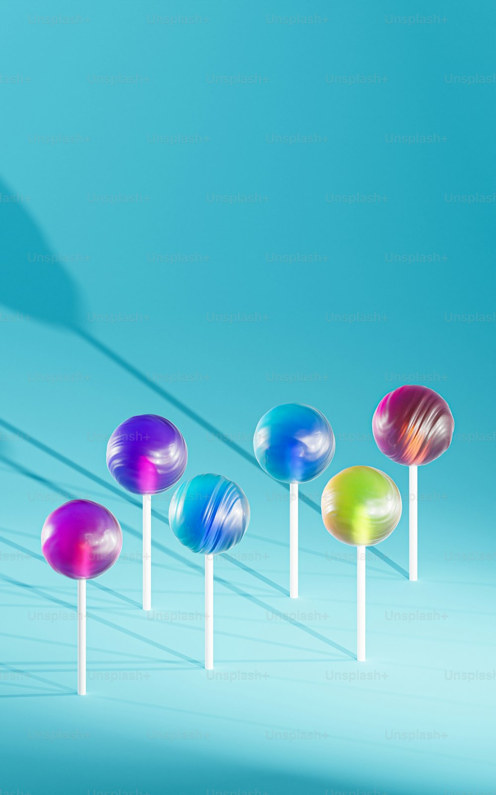 a row of colorful lollipops sitting on top of white sticks