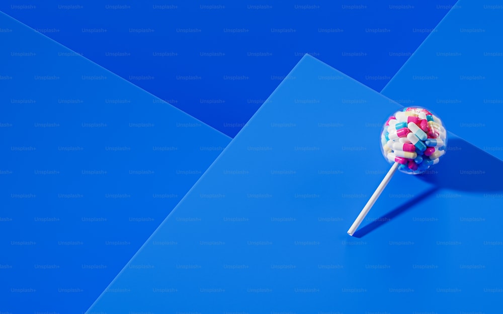 a lollipop with sprinkles on a blue background