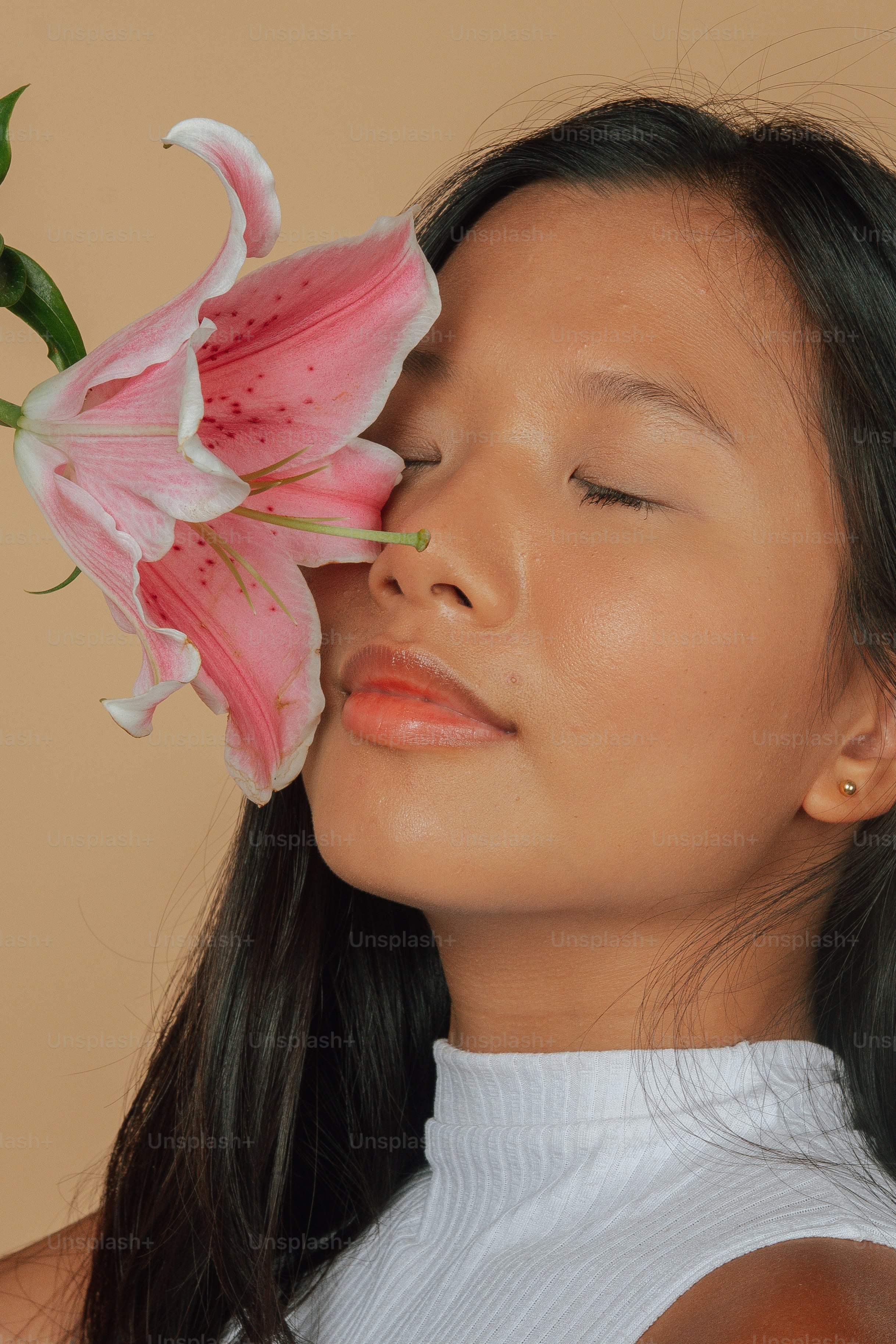 Una mujer con los ojos cerrados y una flor en la mano