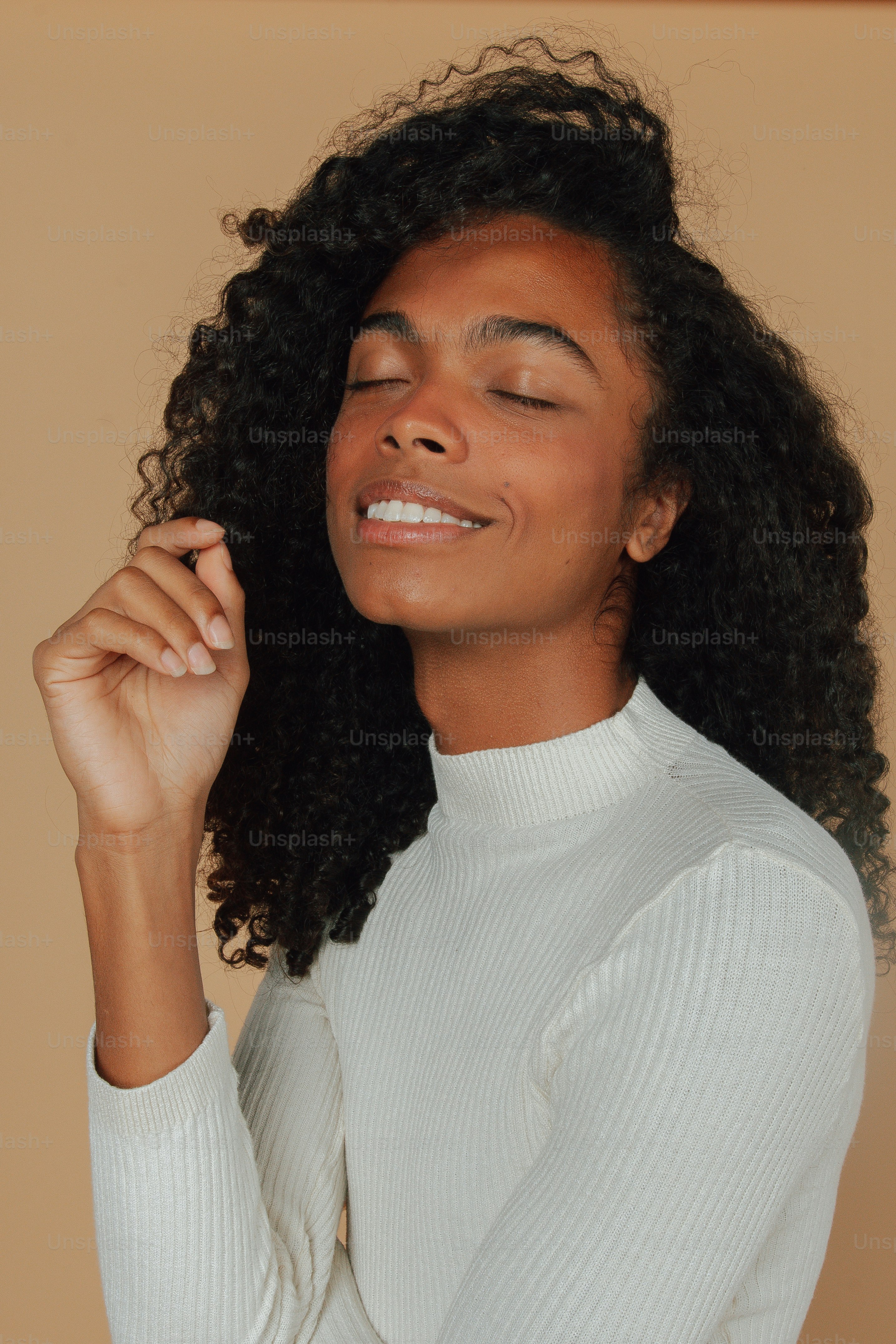 Une femme aux cheveux bouclés sourit