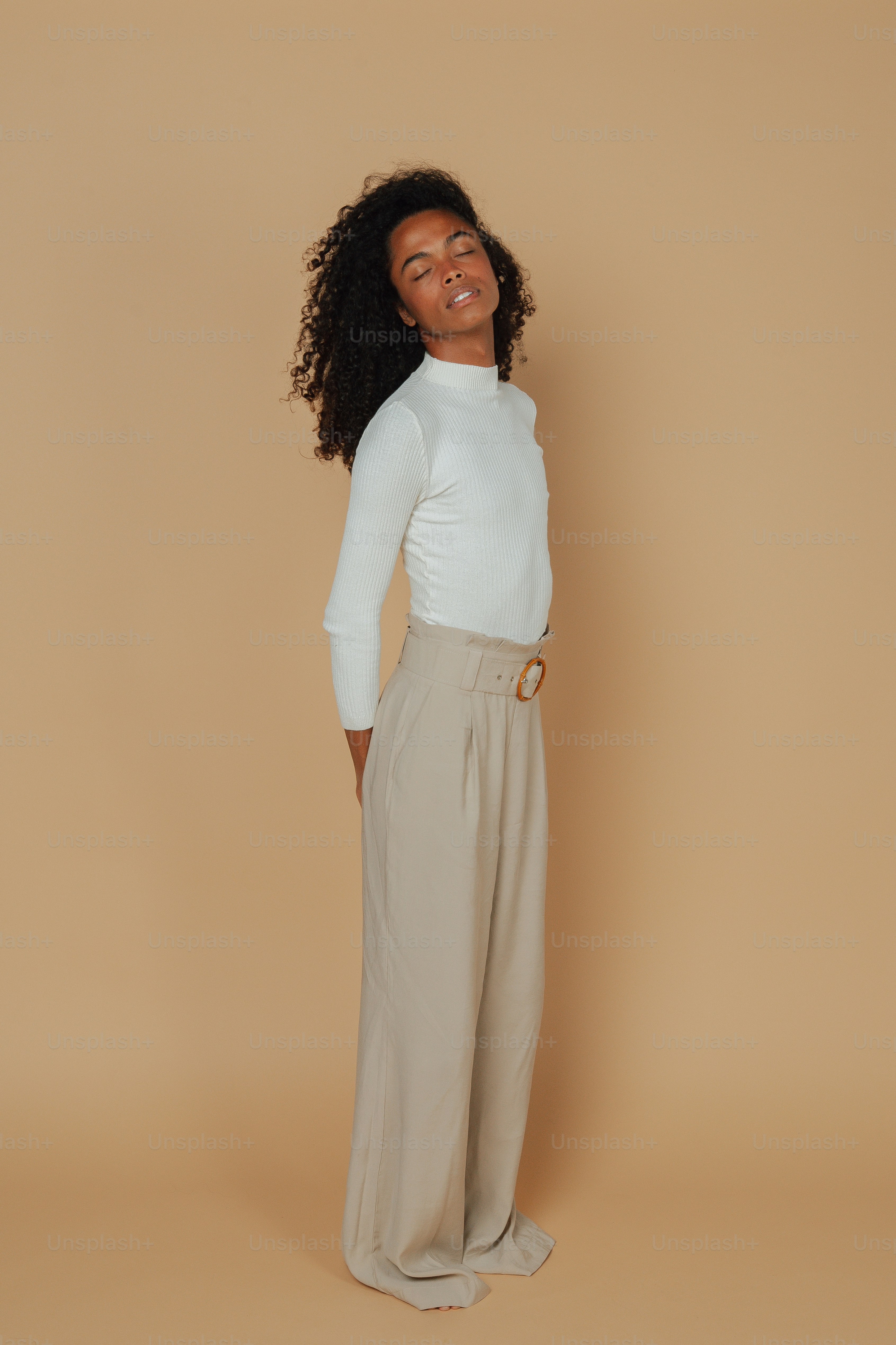 Una mujer parada frente a un fondo bronceado