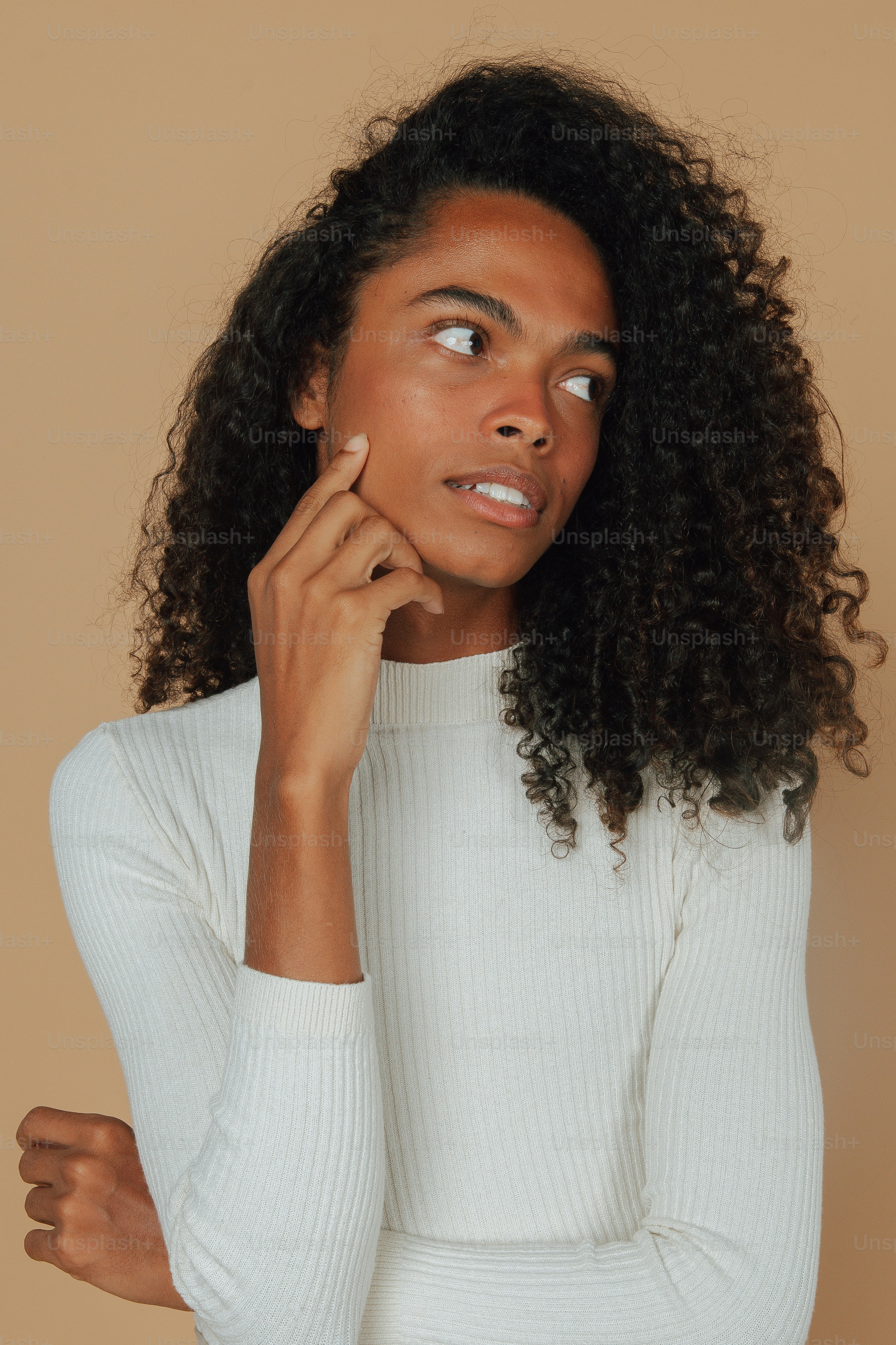 Una mujer con cabello rizado posando para una foto