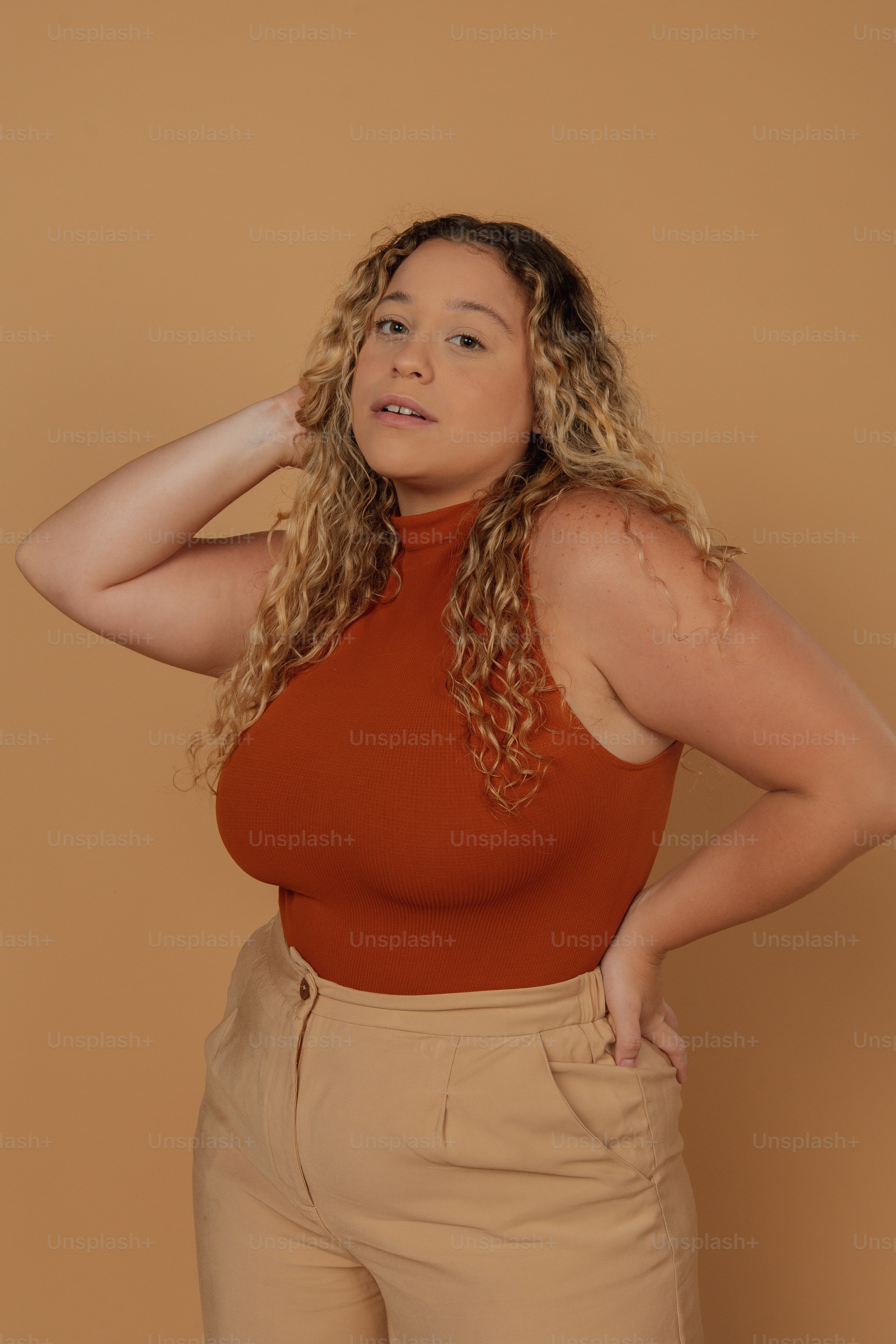 Eine Frau mit rotem Oberteil und hellbrauner Hose