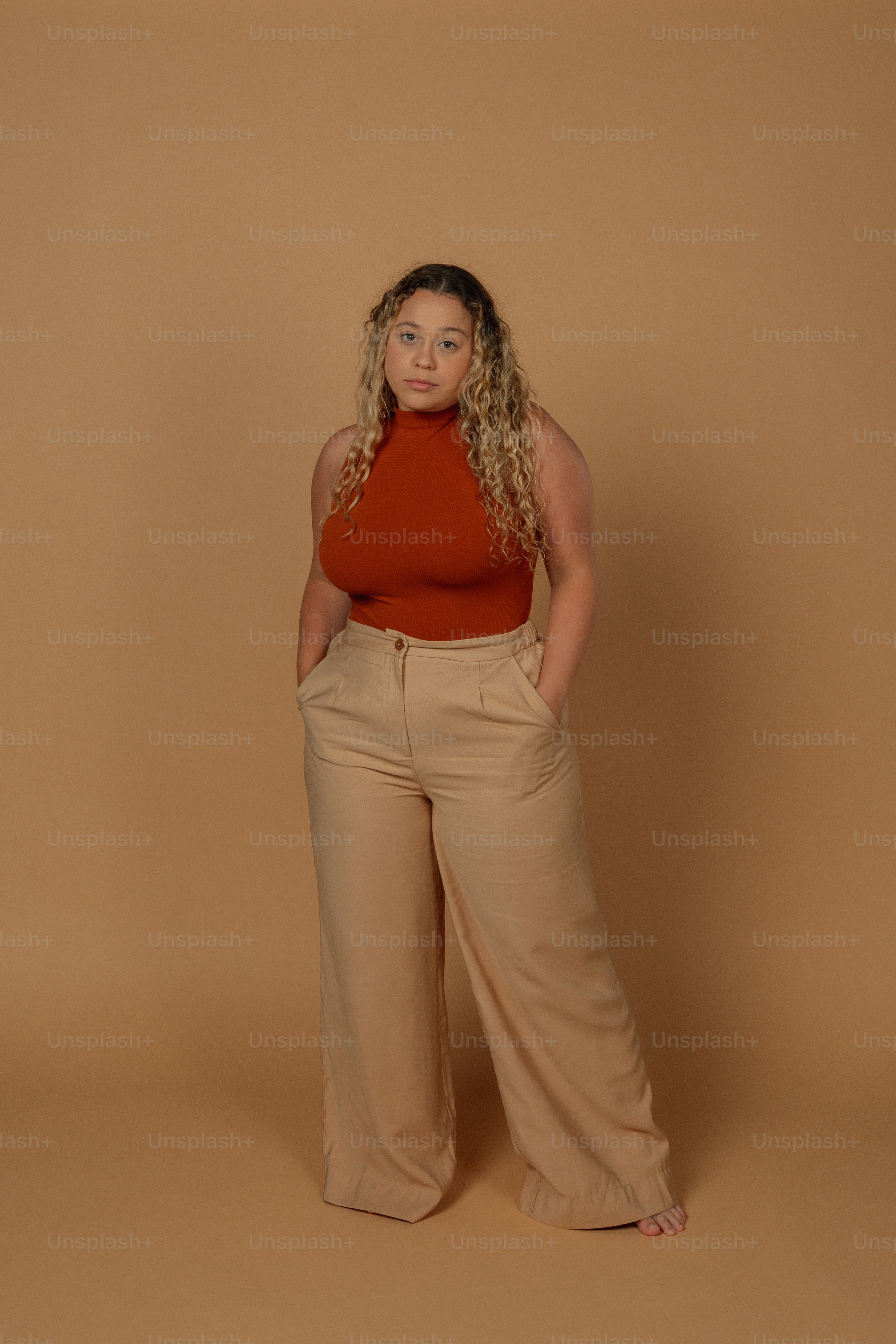 a woman in a red top and tan pants