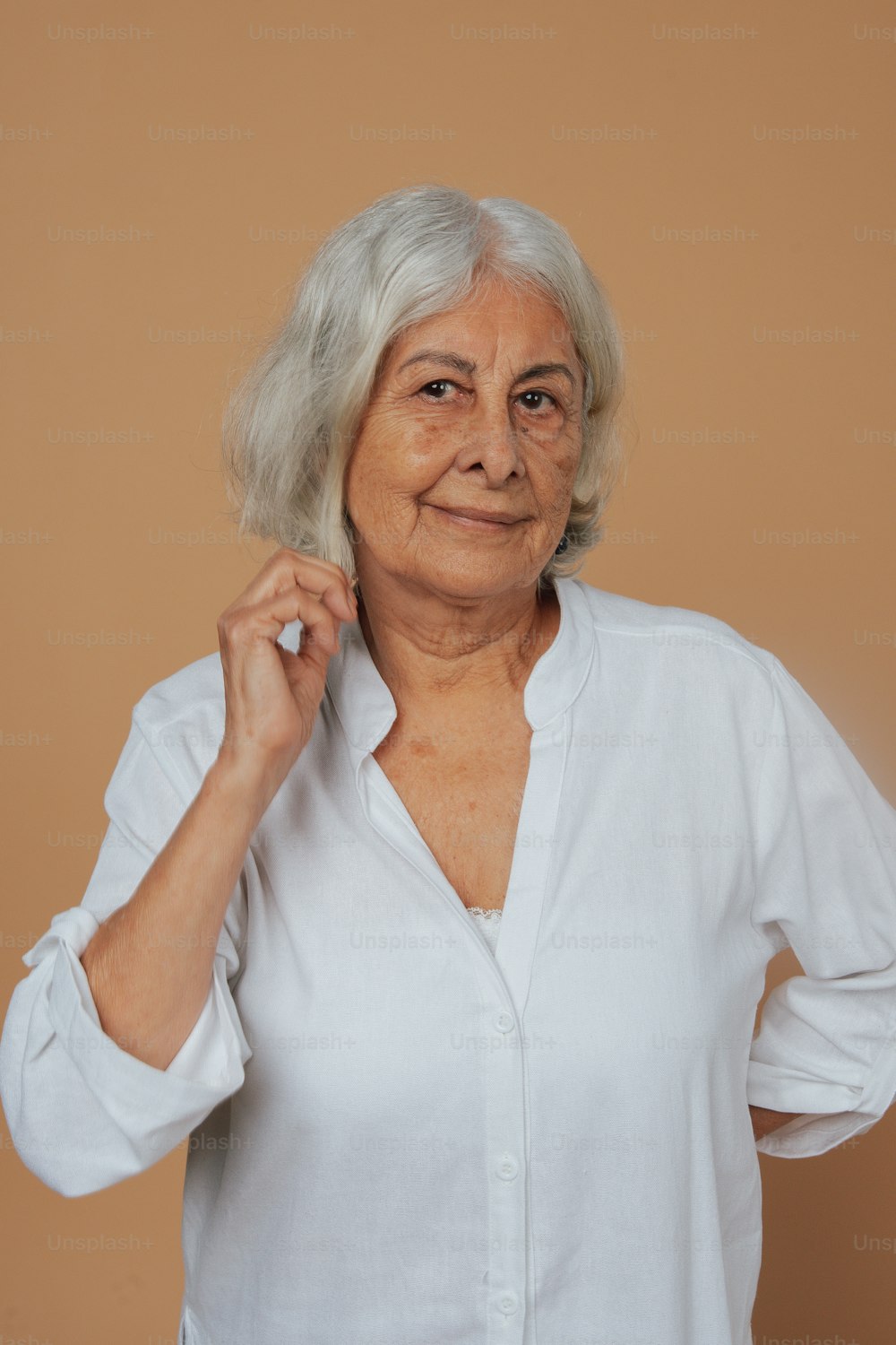 Una donna in una camicia bianca in posa per una foto