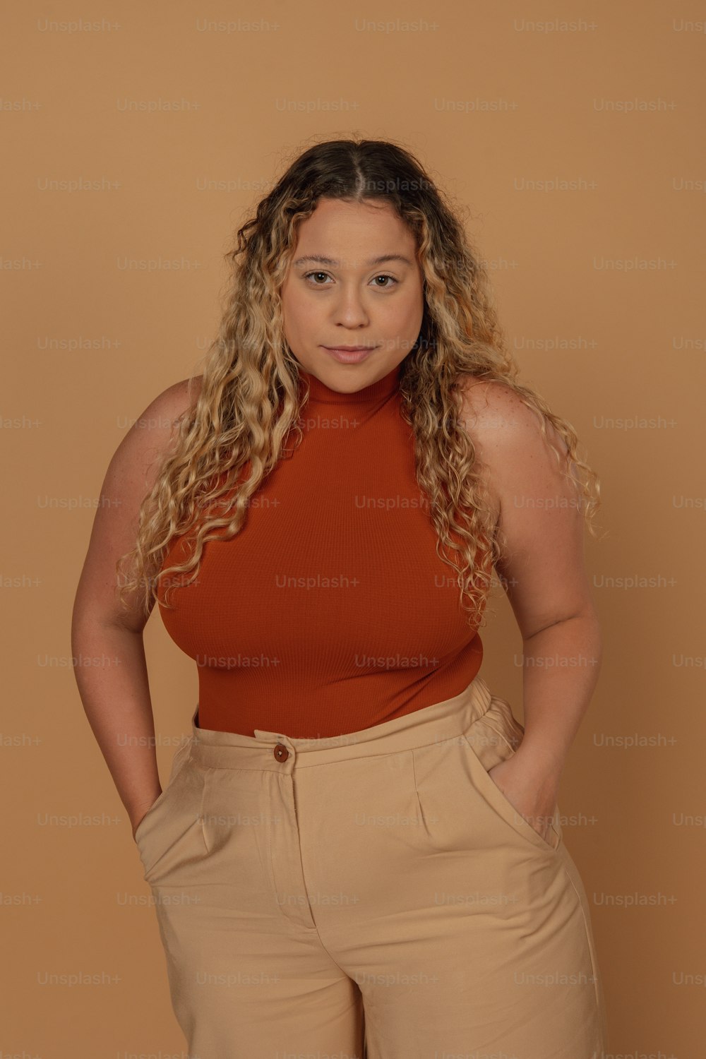a woman in a red top and tan pants