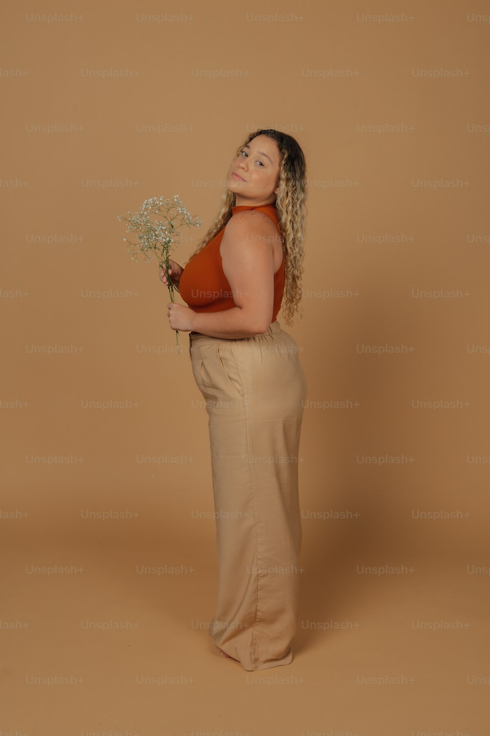 a woman holding a bunch of flowers in her hands