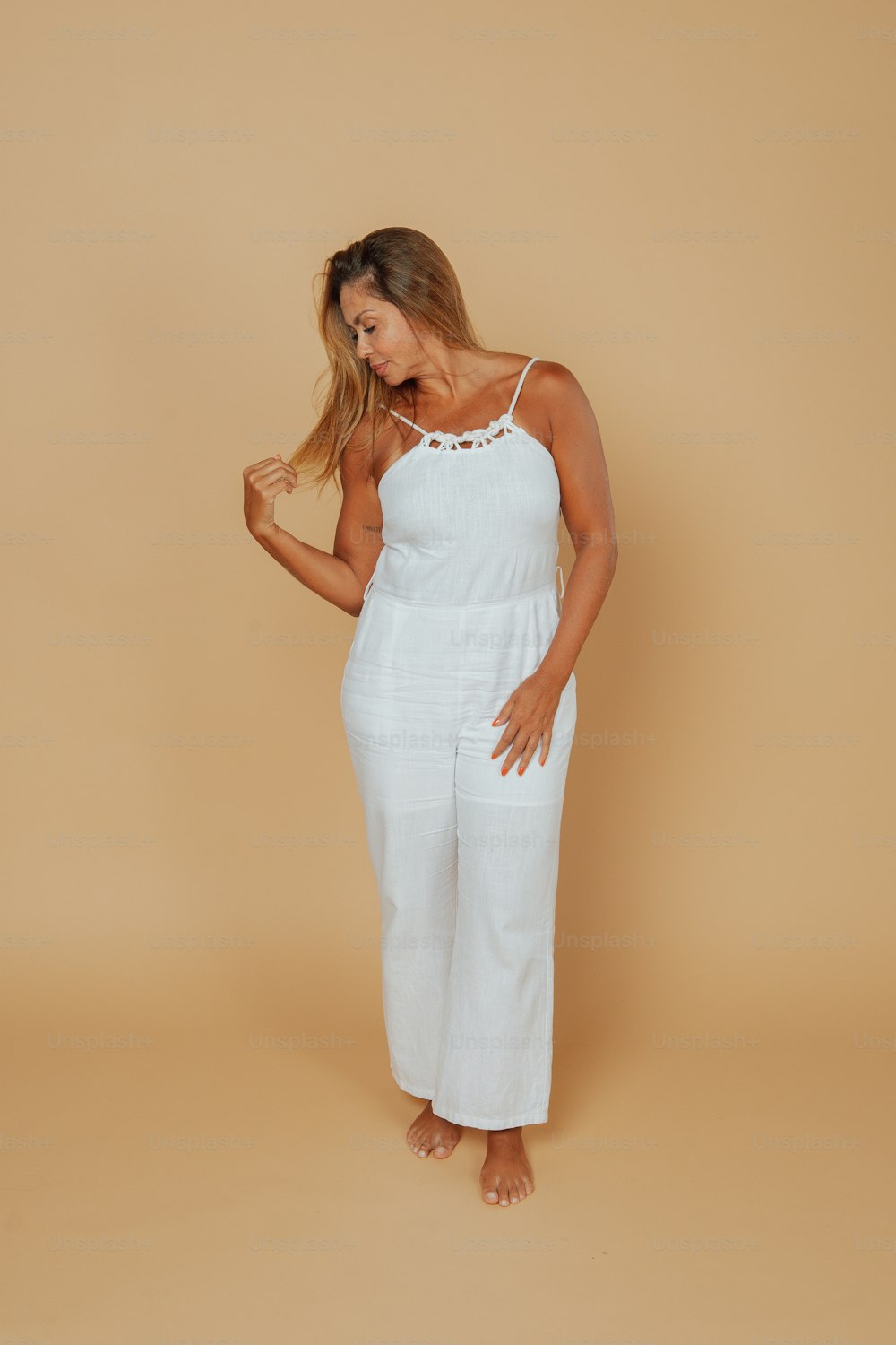 a woman in a white jumpsuit posing for a picture