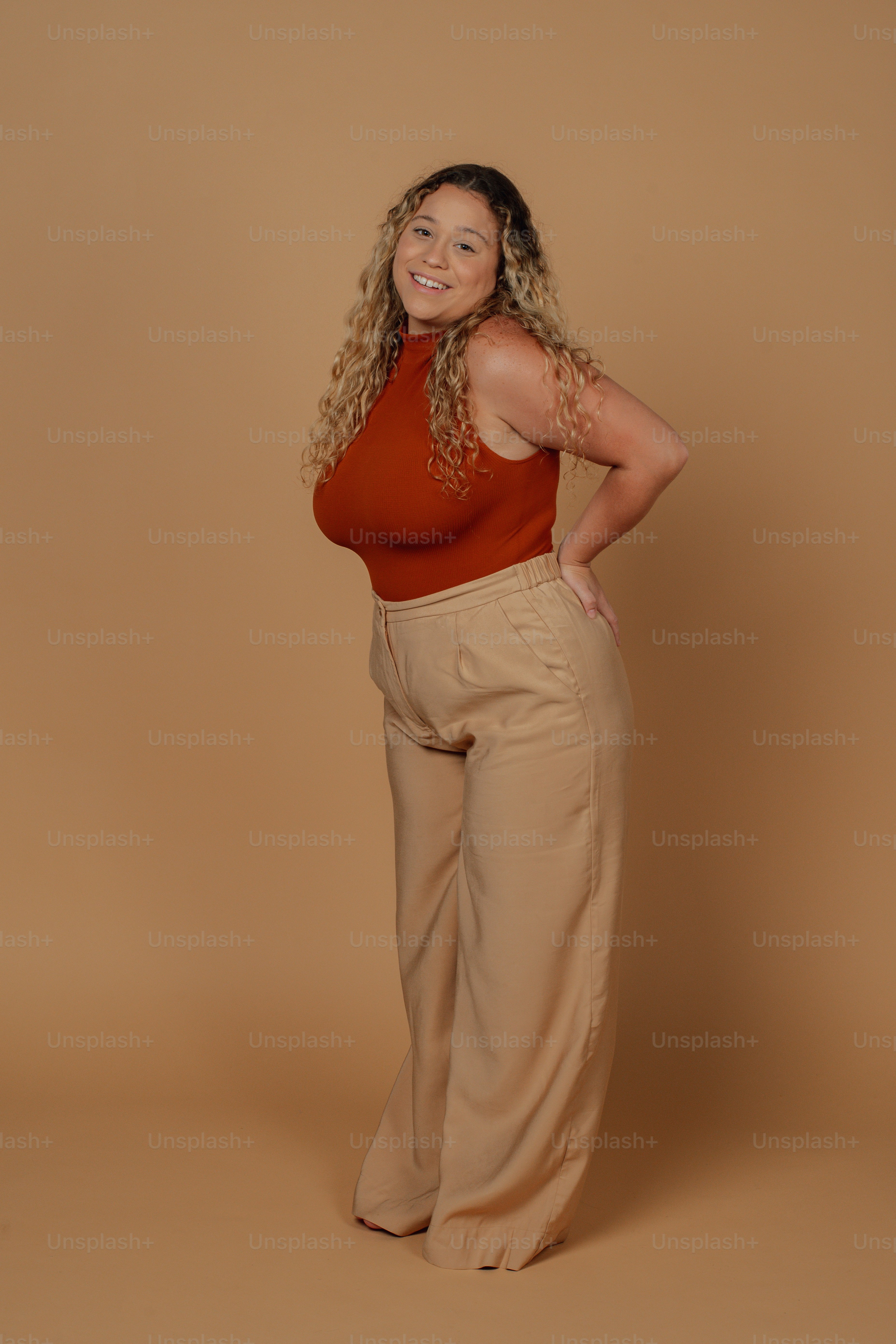 a woman in a red top and tan pants