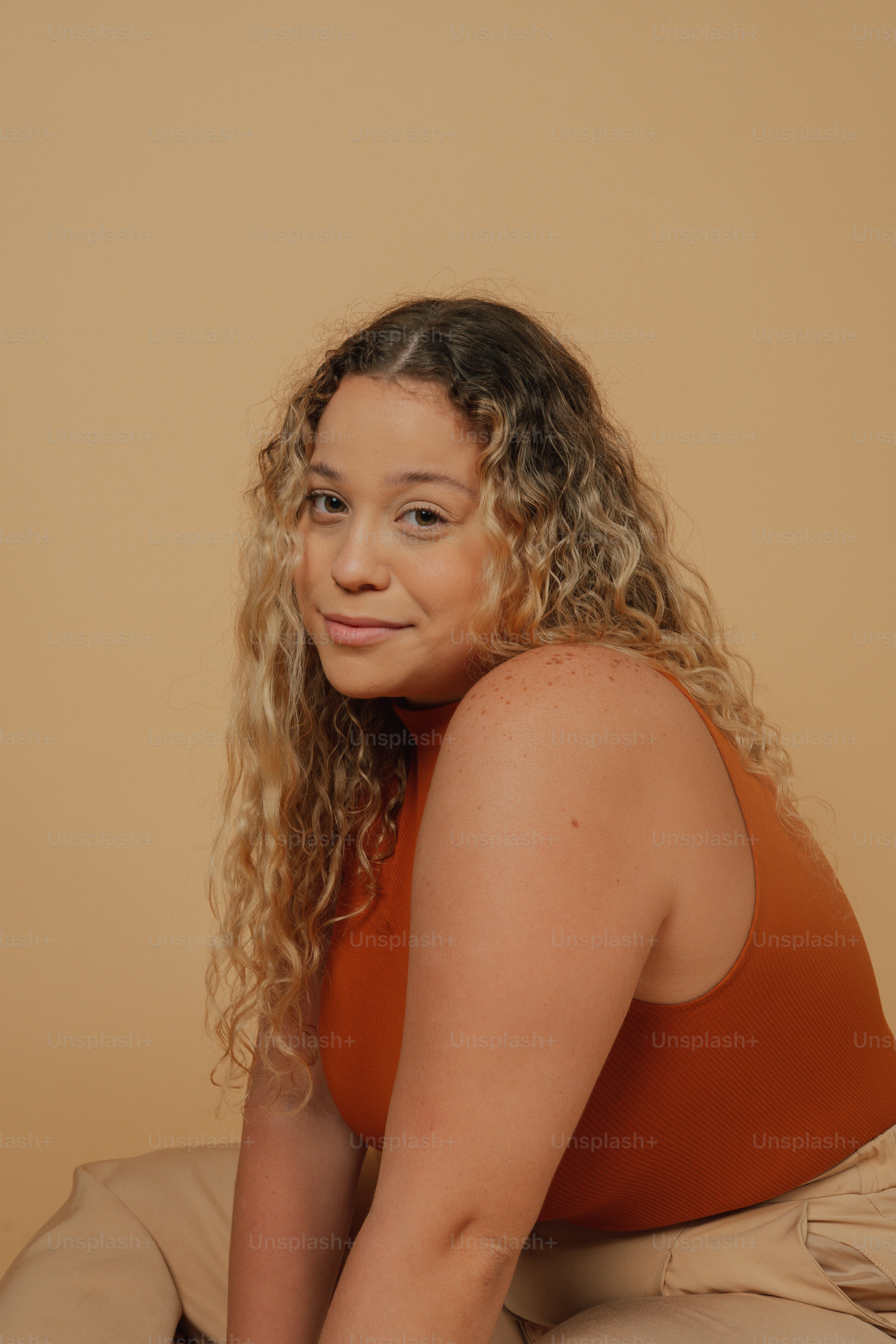 Una mujer con el pelo rizado sentada en el suelo