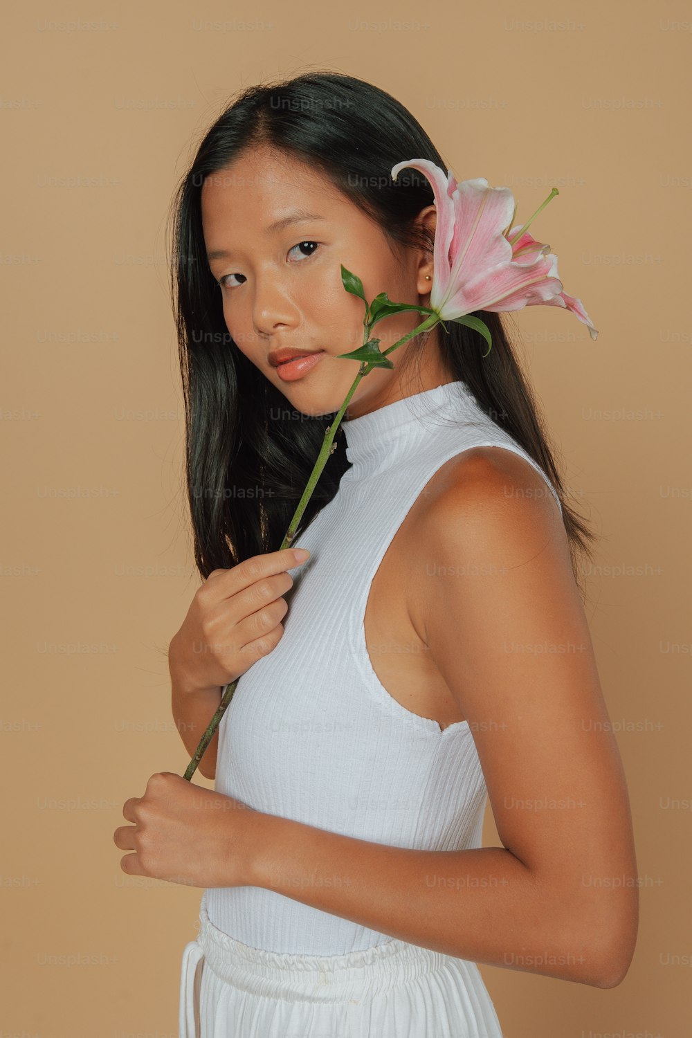 a young girl holding a flower in her hand