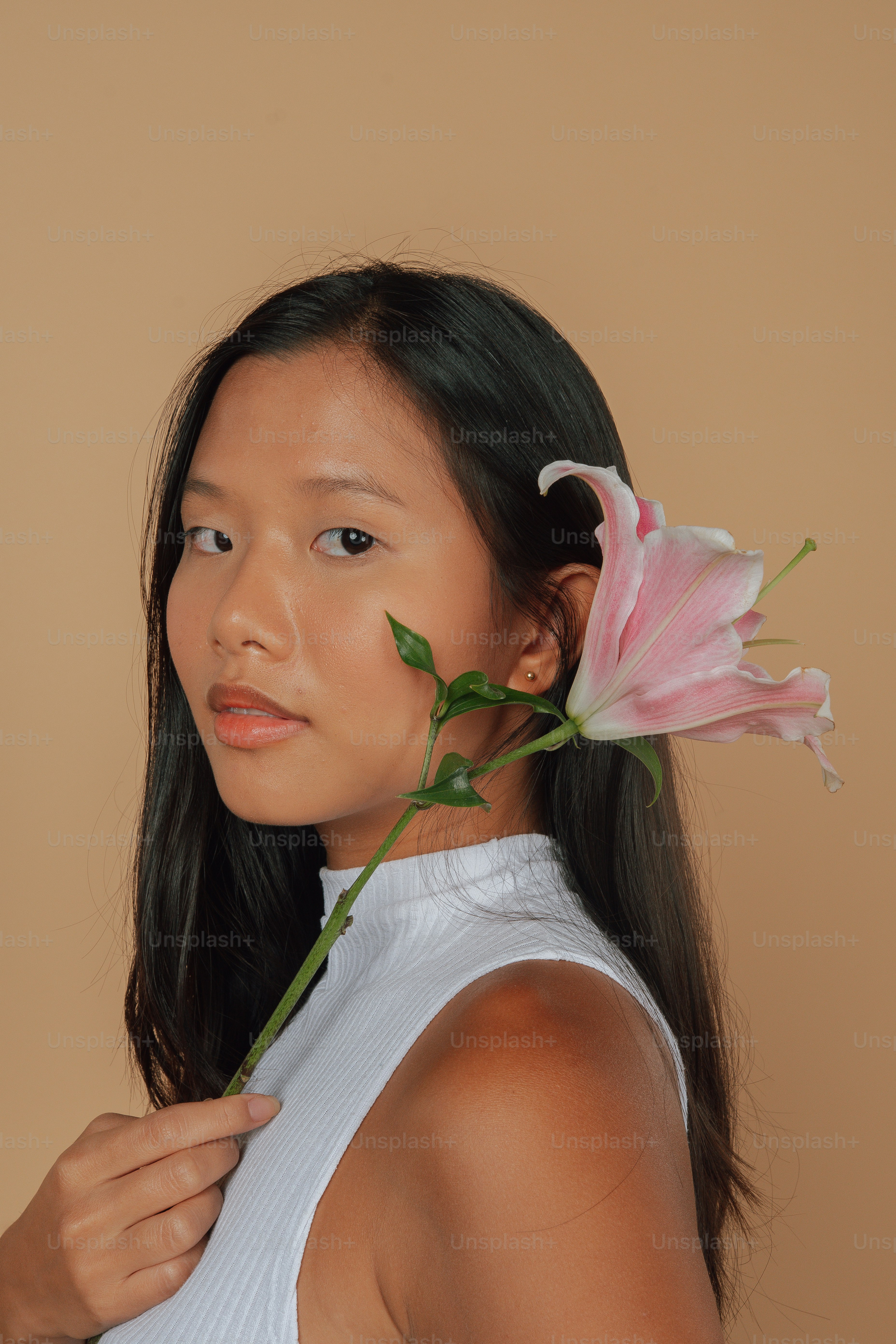 a woman holding a flower in her hair
