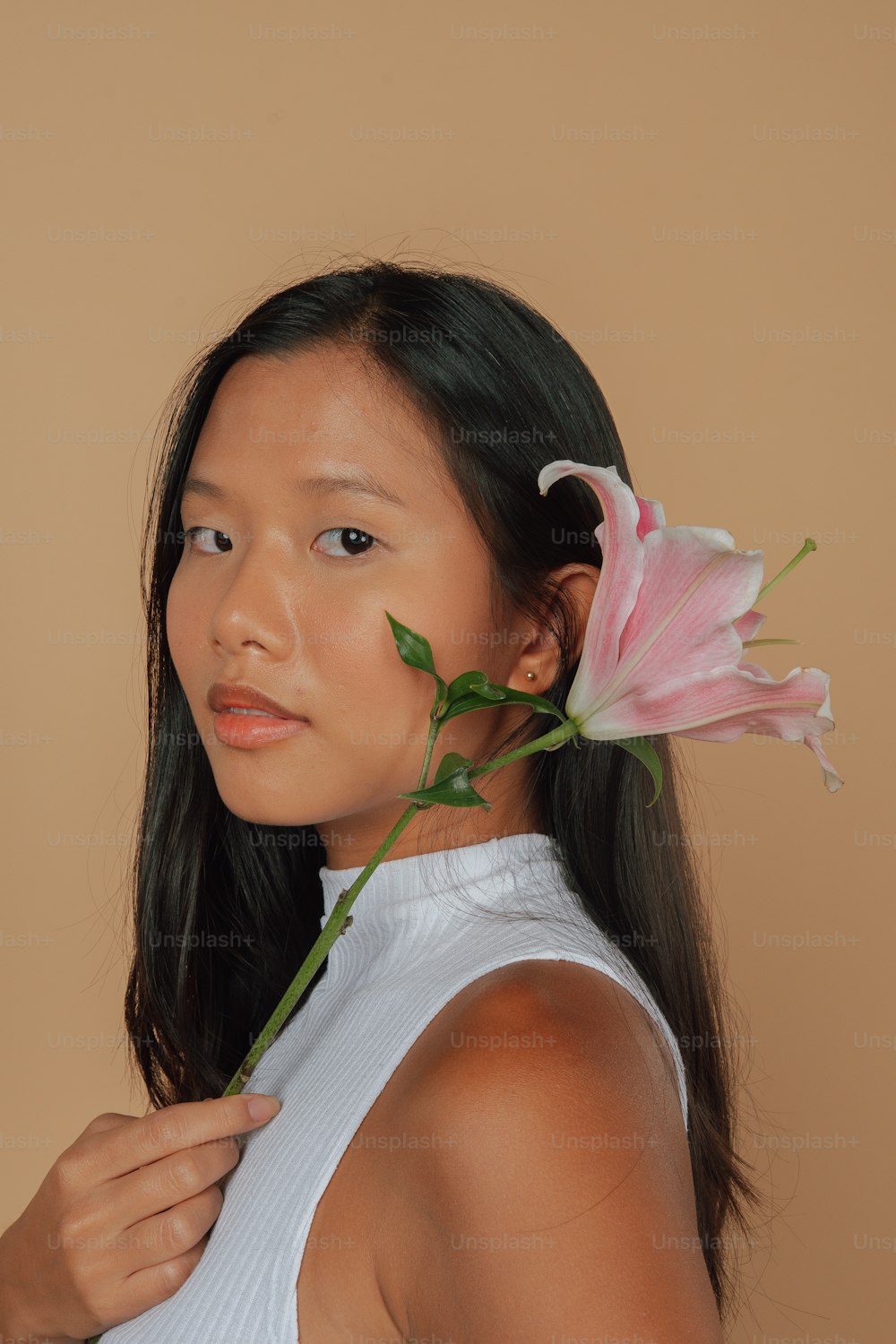 a woman holding a flower in her hair