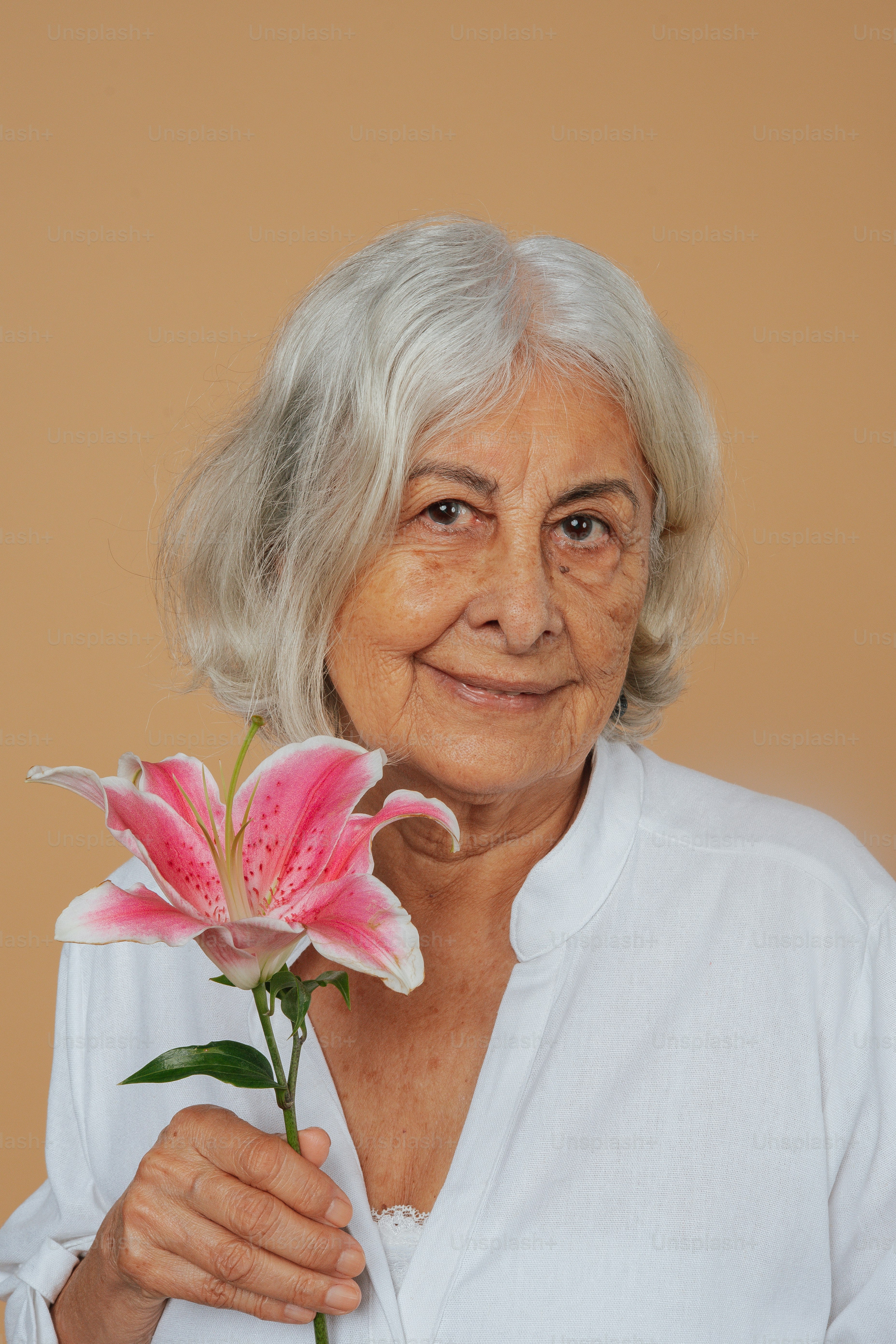 Eine Frau mit einer rosa Blume in der Hand