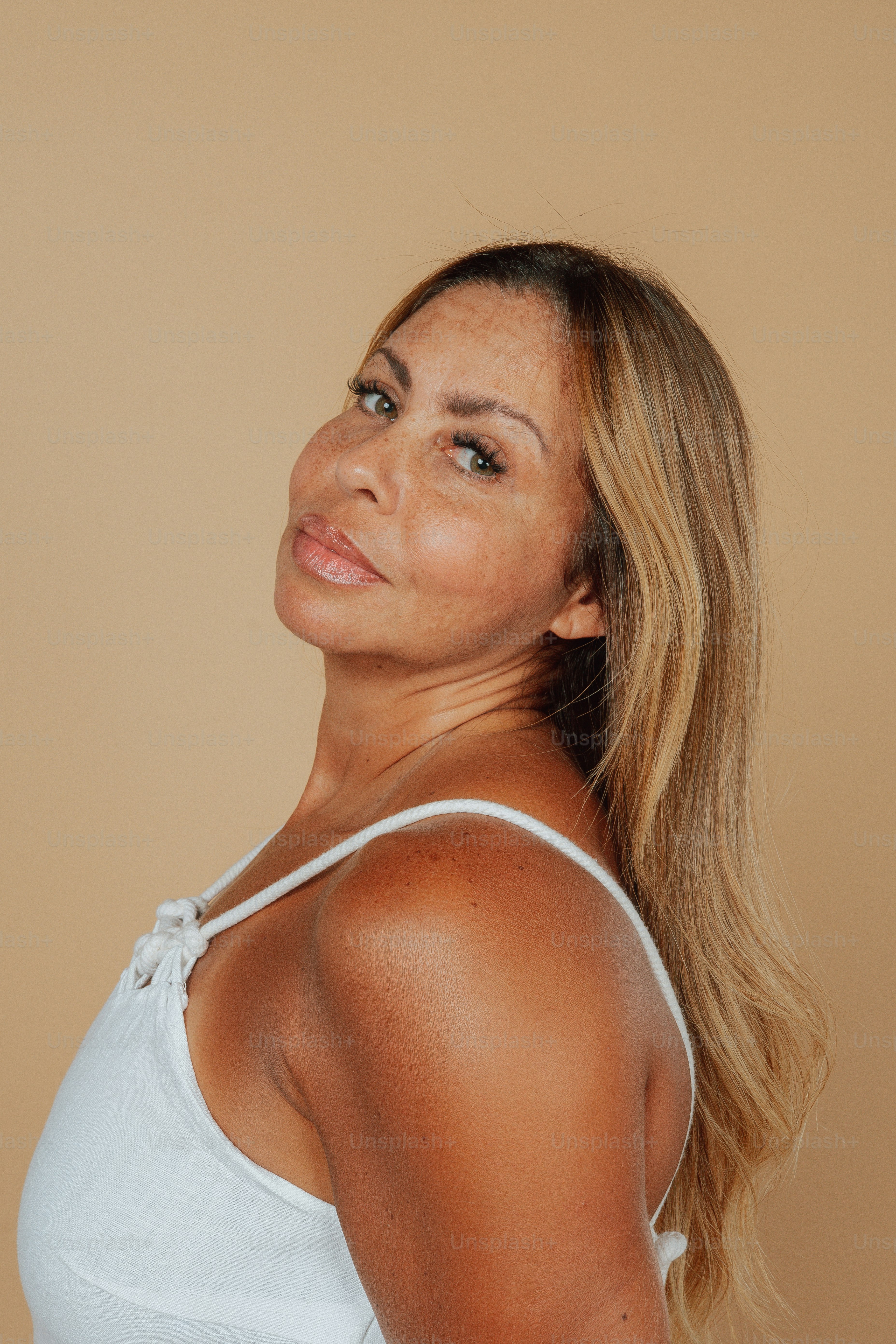 Eine Frau in einem weißen Tanktop posiert für ein Foto