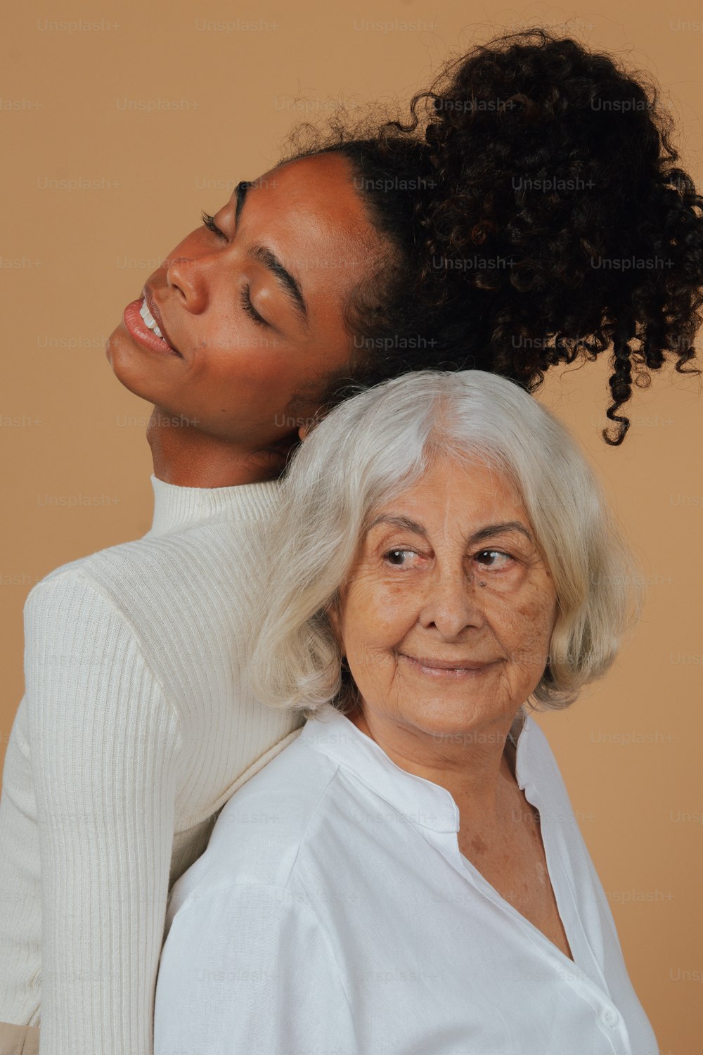 Eine ältere Frau hält den Kopf einer jüngeren Frau
