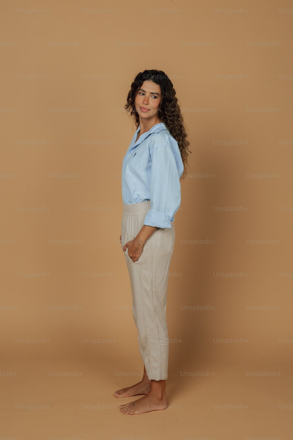 a woman standing in front of a tan background