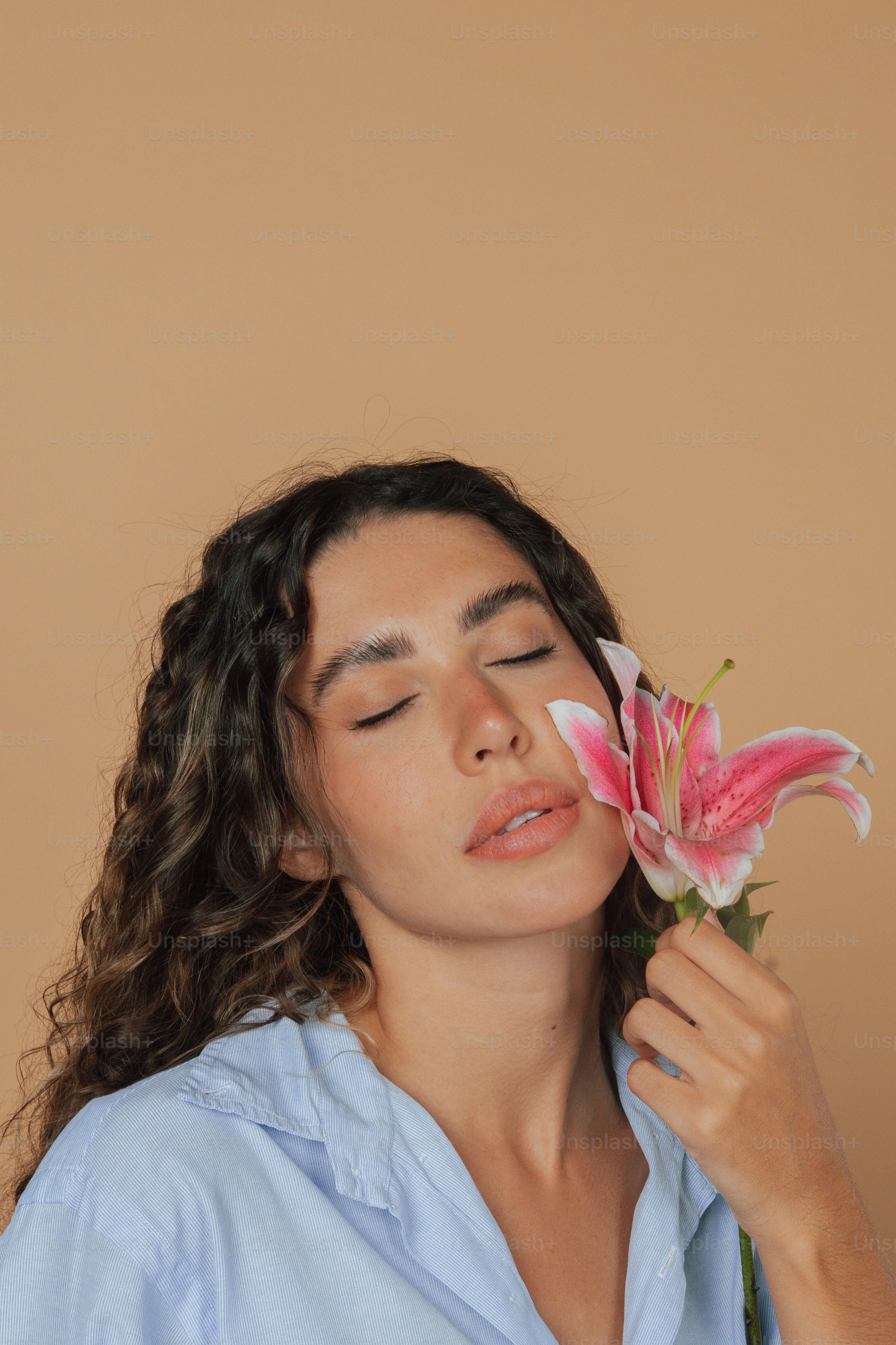 Una donna che tiene un fiore rosa nella mano destra