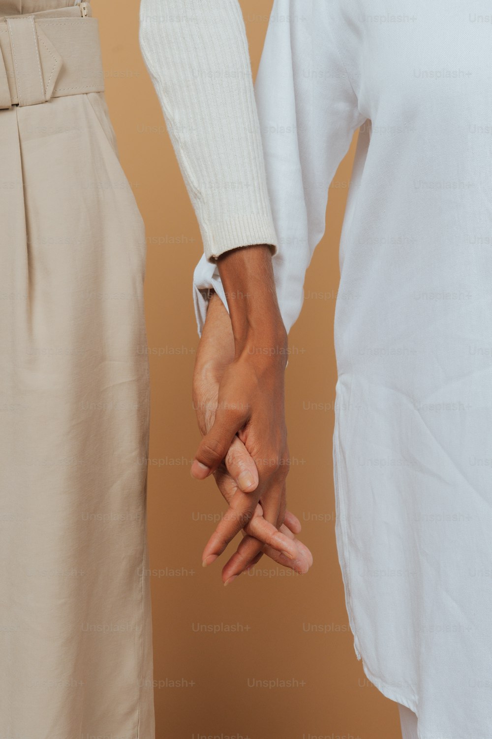 Un primer plano de dos personas tomadas de la mano