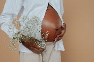 a pregnant woman holding a bouquet of baby's breath