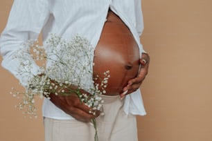 Eine schwangere Frau, die einen Strauß Babys Atem hält