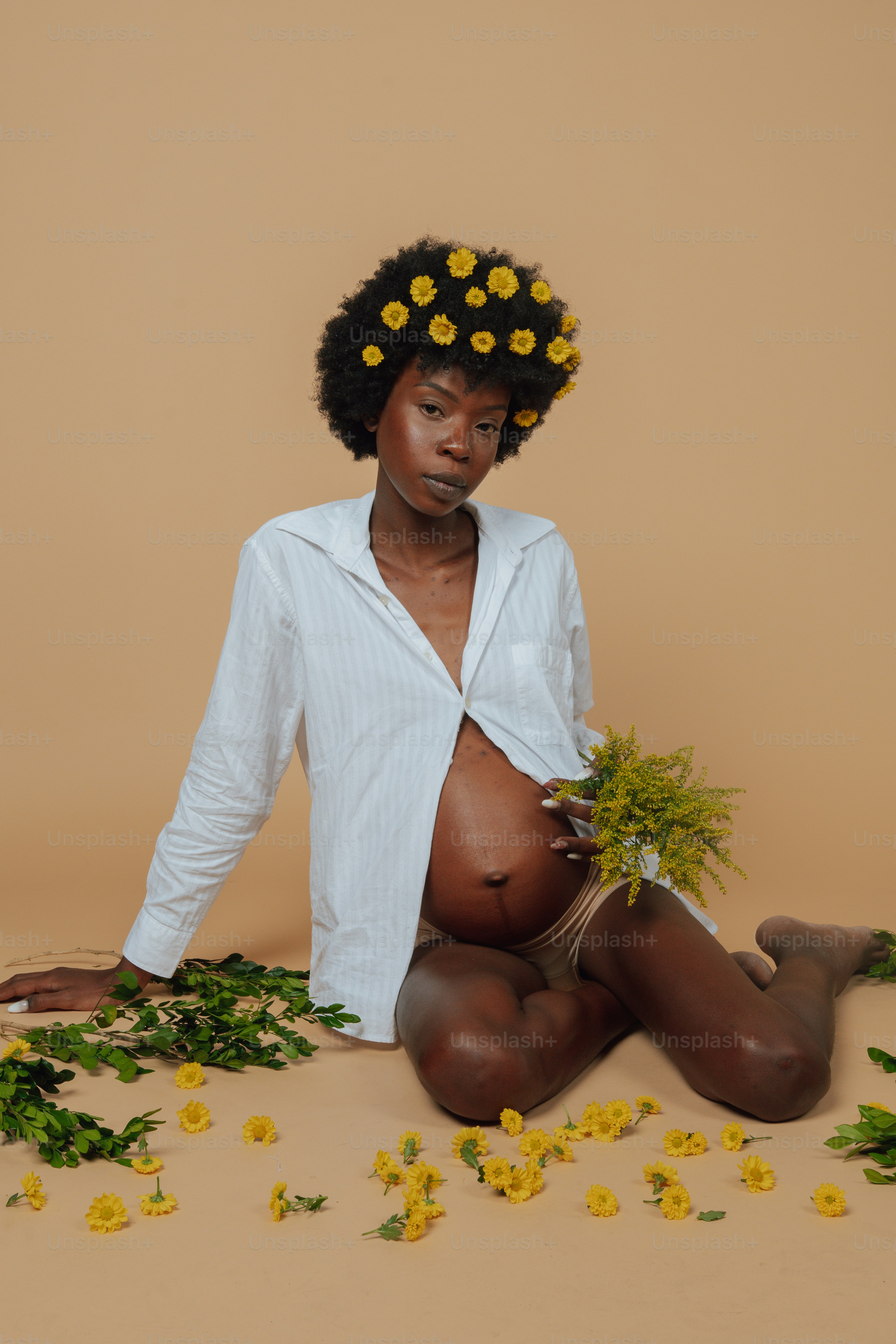 Eine Frau, die mit Blumen im Haar auf dem Boden sitzt