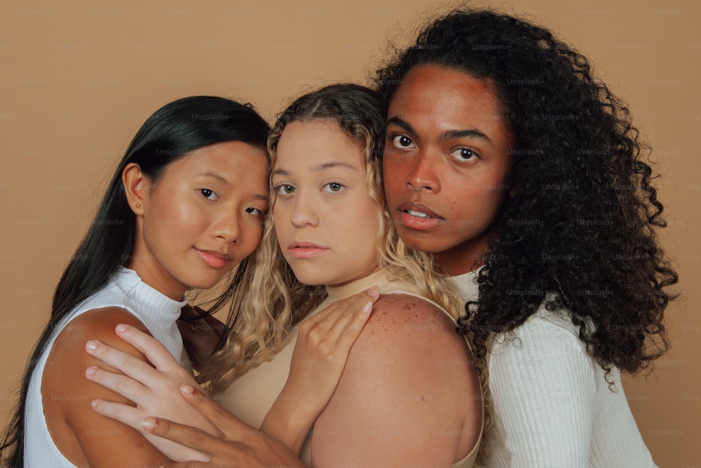 a group of three women standing next to each other