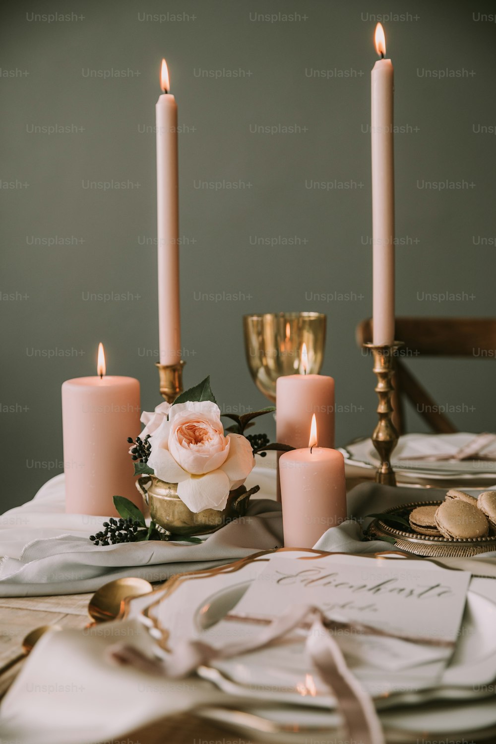 a table topped with candles and plates covered in napkins