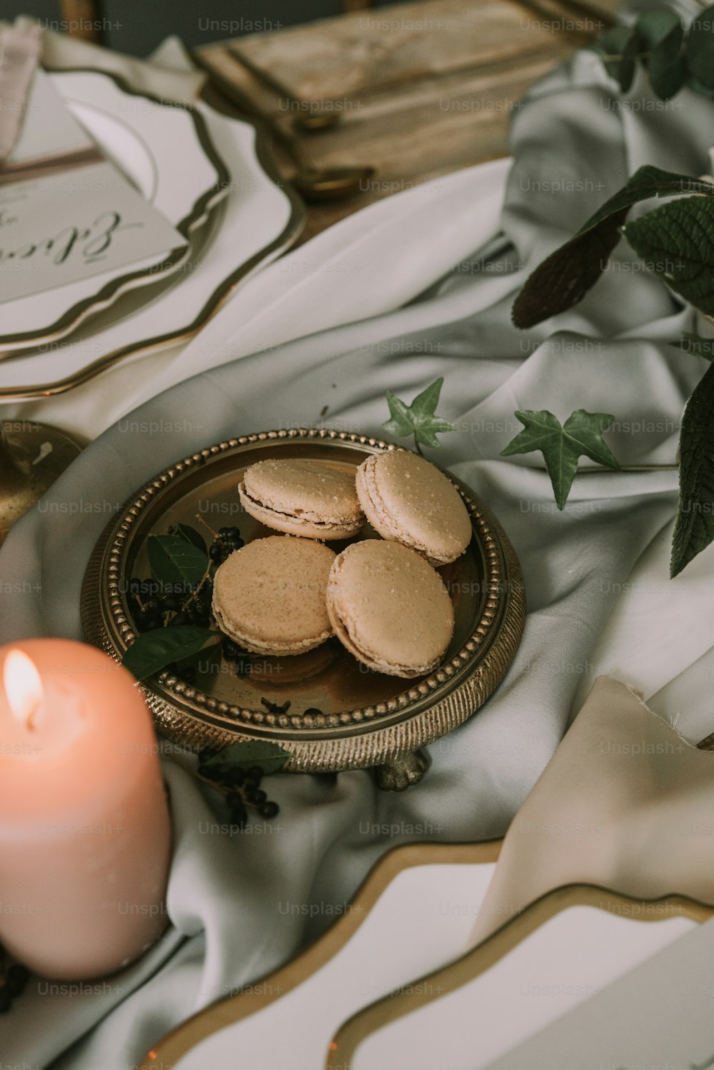 a plate of cookies next to a lit candle
