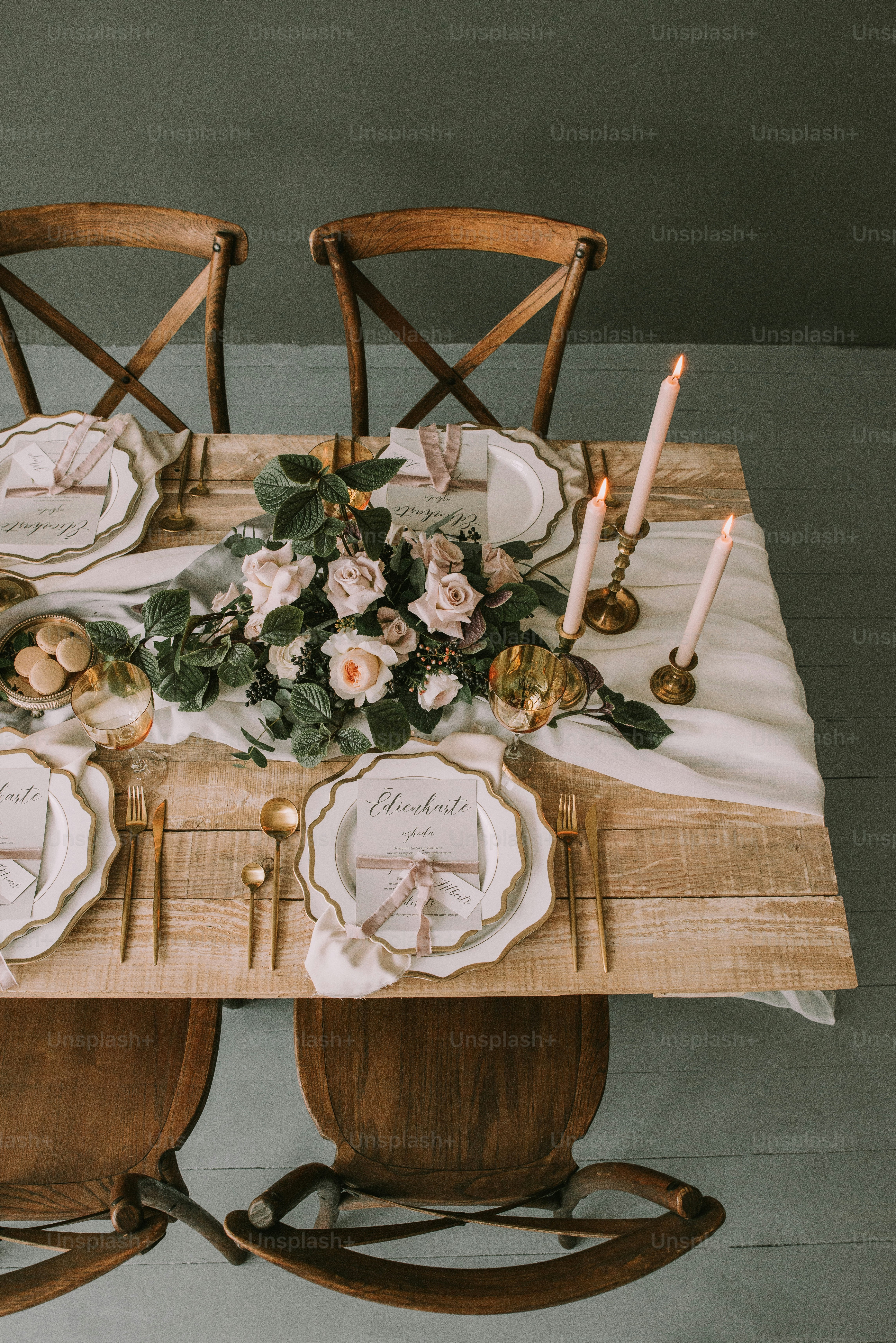 una mesa de madera cubierta con platos y flores