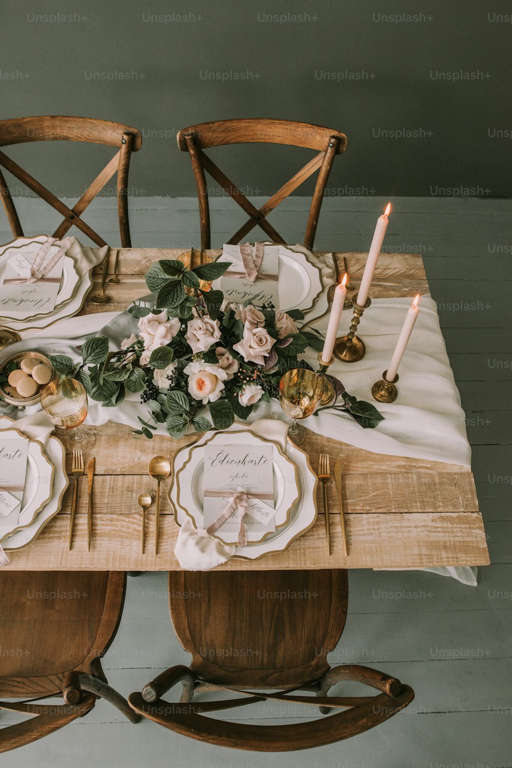 a wooden table topped with plates and flowers